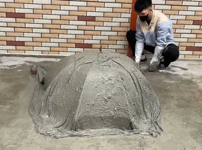 ریختن مخلوط سیمان روی چتر قدیمی برای ساخت گلدان
